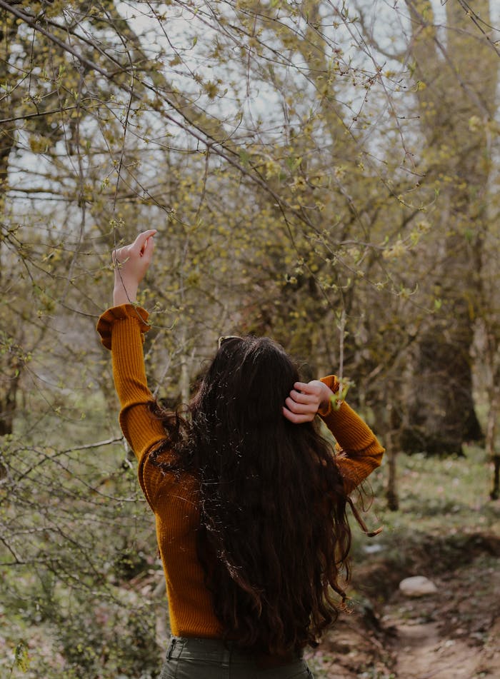 Back View of Person Touching a Tree